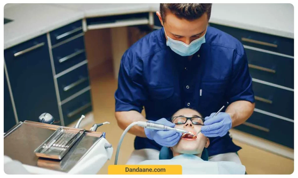 دندانپزشک در حال معاینه و درمان بیمار 